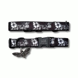 May include: Black dog collar with a floral and skull pattern. The collar has a black buckle and a metal moth charm. The text "lilith" and a phone number are printed on the buckle.