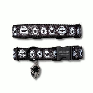 May include: A black pet collar featuring a repeating white pattern of insects and bats inside ornate oval frames. The collar includes a black plastic buckle engraved with the text Shadow 123-456-7890 and a silver-toned oval pendant with a black bat.