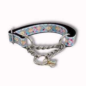 Pode incluir: Uma coleira para cães com um padrão decorativo com bules, corações e xadrez em um fundo azul claro. A coleira tem um interior preto e uma corrente prateada com um pingente. A coleira é projetada para cães médios a grandes.