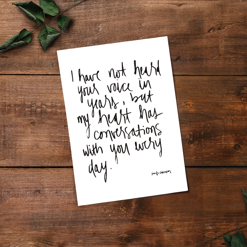 May include: A white card with black handwritten text that reads "I have not heard your voice in years, but my heart has conversations with you every day." The text is in a cursive font and the signature "your name" is at the bottom right corner of the card.
