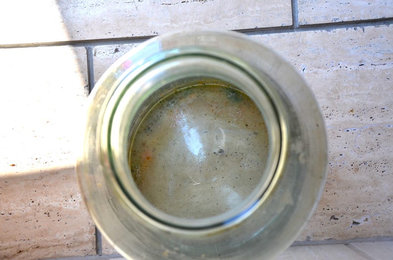 K&ouml;nnte beinhalten: Ein klares Glasgef&auml;&szlig; mit einer breiten &Ouml;ffnung, gef&uuml;llt mit einer hellgr&uuml;nen Fl&uuml;ssigkeit. Die Fl&uuml;ssigkeit hat eine tr&uuml;be, schaumige Textur.