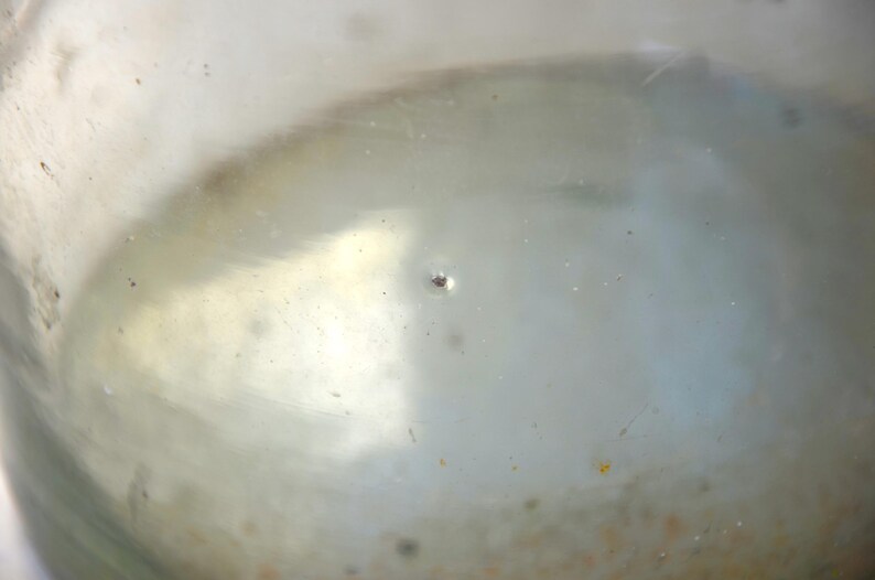 K&ouml;nnte beinhalten: Nahaufnahme eines durchsichtigen Glasbeh&auml;lters mit einem kleinen Loch im Boden. Der Beh&auml;lter ist mit einer tr&uuml;ben Fl&uuml;ssigkeit gef&uuml;llt.