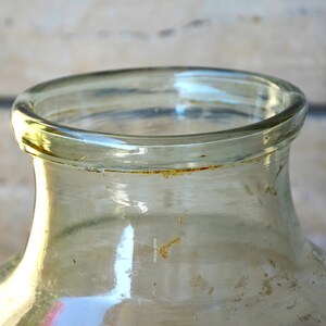 K&ouml;nnte beinhalten: Ein klares Glasgef&auml;&szlig; mit einer breiten &Ouml;ffnung und einem abgerundeten Boden. Das Gef&auml;&szlig; hat eine leicht strukturierte Oberfl&auml;che und zeigt Gebrauchsspuren.