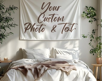 Könnte beinhalten: Ein cremefarbenes Wandbehang mit dem Text "Your Custom Photo & Text" in brauner Schrift hängt über einem Bett mit weißer Bettwäsche und einer braunen Decke. Der Raum ist mit Pflanzen dekoriert.