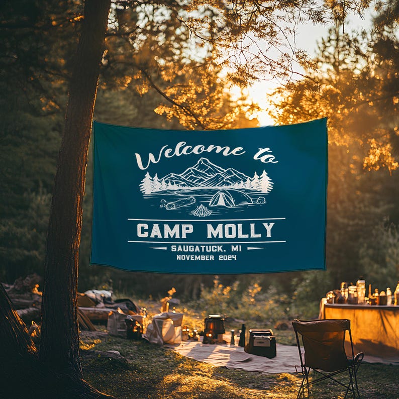 May include: A blue welcome banner with white text that reads "Welcome to Camp Molly - Saugatuck, MI - November 2024". The banner features a stylized illustration of a lake with mountains and trees.