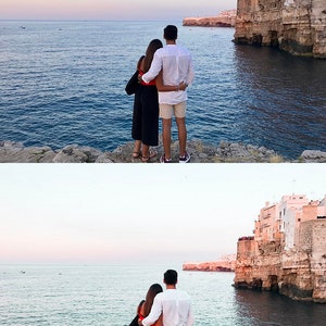 K&ouml;nnte beinhalten: Ein Paar steht auf einer felsigen Klippe mit Blick auf das Meer, im Hintergrund eine in die Klippe gebaute Stadt. Der Himmel ist zartblau mit einem Hauch von Rosa.