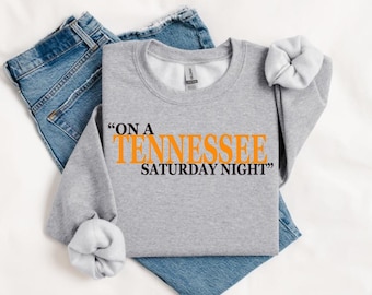 May include: Gray sweatshirt with the text "On a Tennessee Saturday Night" in orange letters.