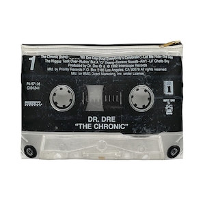 May include: A clear, rectangular zippered pouch featuring a black and white cassette tape design. The design includes the text "DR. DRE THE CHRONIC" and song titles. The pouch has a gold zipper and is likely used for storage.