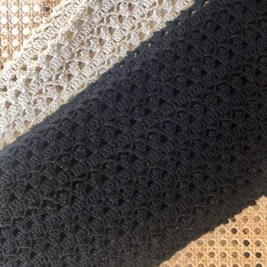 Puede incluir: Dos muestras de tejido de crochet, una negra y otra beige, con un patr&oacute;n tejido. Las muestras se colocan sobre una superficie tejida.