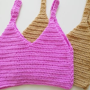 May include: Two crocheted tank tops, one pink and one brown, with thin straps.