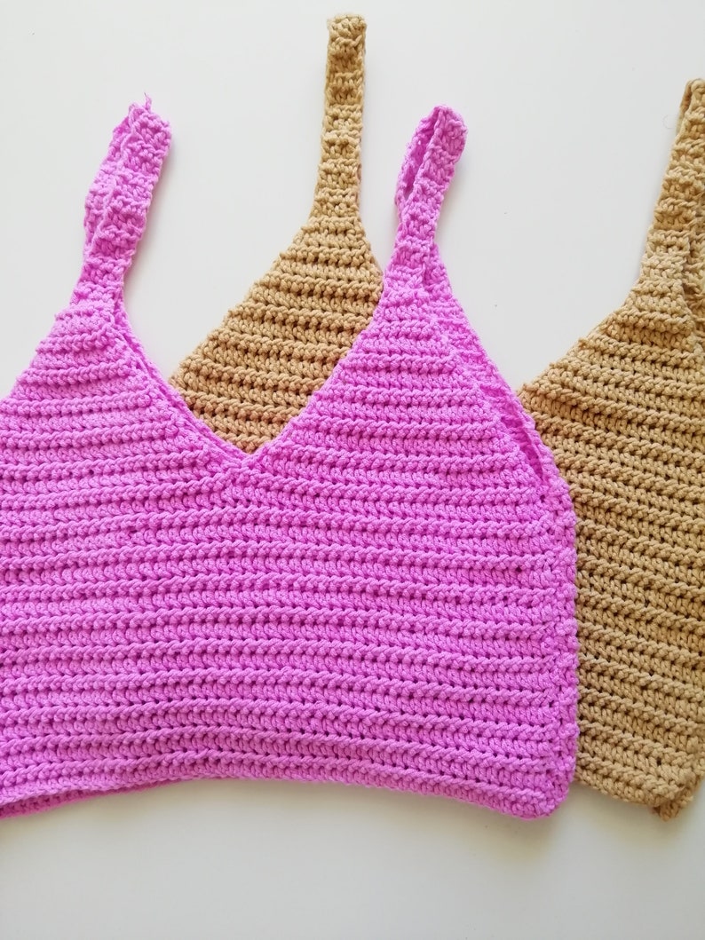 May include: Two crocheted tank tops, one pink and one brown, with thin straps.