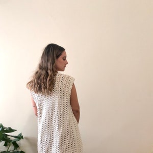 Puede incluir: Un top blanco de crochet sin mangas, de corte holgado y con un delicado patr&oacute;n de calado.