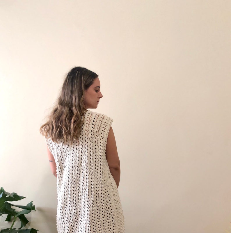 Puede incluir: Un top blanco de crochet sin mangas, de corte holgado y con un delicado patr&oacute;n de calado.