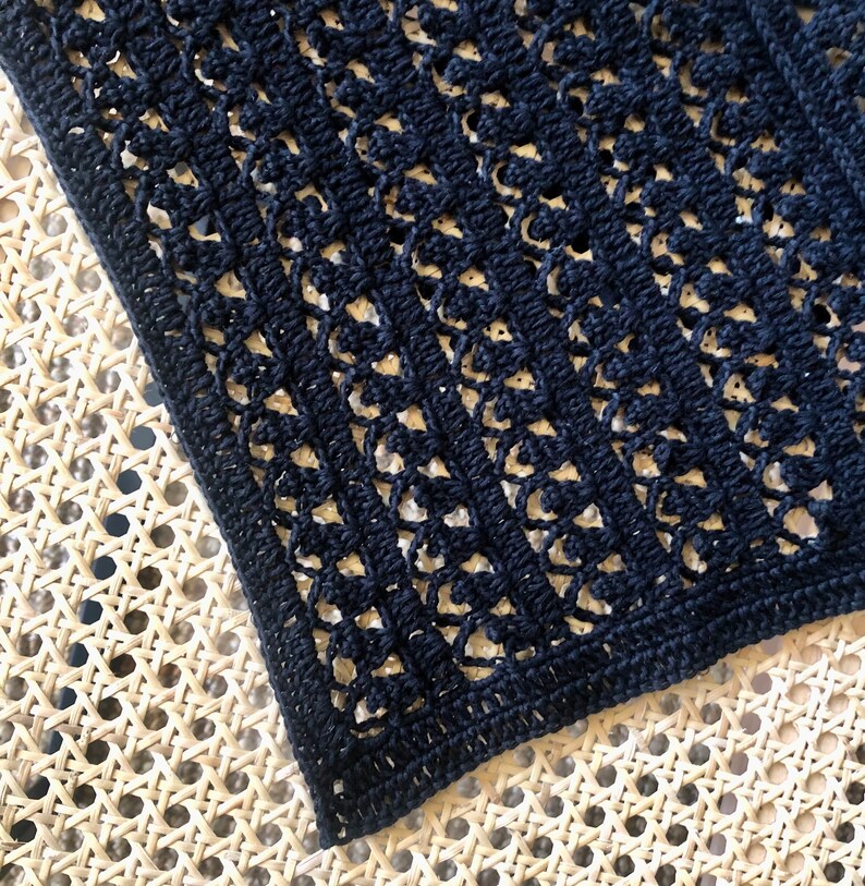 Puede incluir: Tela de crochet negra con un delicado patr&oacute;n de calado. La tela tiene forma cuadrada y est&aacute; hecha con un hilo fino.