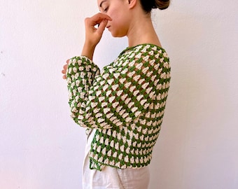 May include: A green and white crochet top with a loose fit and long sleeves. The top is made of a lightweight, breathable fabric and has a relaxed, casual style.