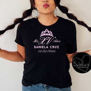May include: Black t-shirt with a pink crown and the text "Mis XV A&ntilde;os Daniela Cruz 05/27/2023"