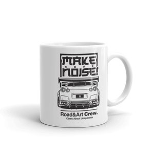 May include: White ceramic mug featuring a black and white illustration of a car and the text "MAKE SOME NOISE!" and "Road&Art Crew. Cares About Uniqueness."