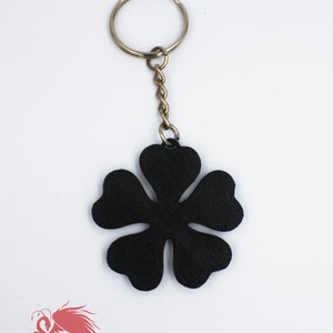 May include: Black flower-shaped keychain with a silver key ring and chain.