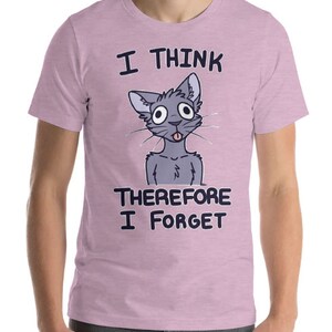 Puede incluir: Una camiseta rosa con un gato de dibujos animados y el texto "Pienso, luego olvido".