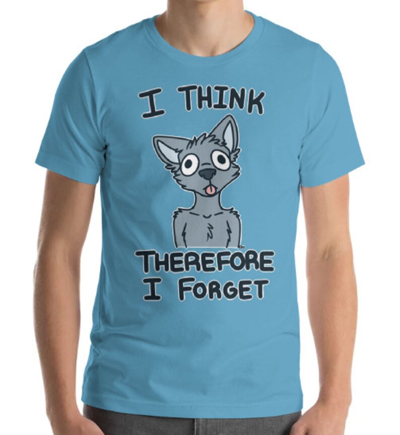 Puede incluir: Una camiseta azul claro con un lobo gris de dibujos animados con la lengua fuera. El texto "Pienso, luego olvido" est&aacute; impreso en la camiseta.