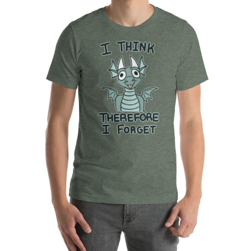 Puede incluir: Una camiseta verde con un drag&oacute;n de dibujos animados y el texto "Pienso, luego olvido".