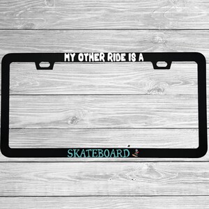 Close-up of "My Other Ride Is A Skateboard" license plate frame showing fade-proof print quality