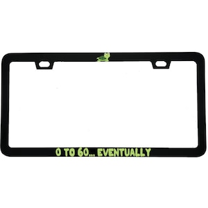 May include: Black license plate frame with the text "0 to 60... EVENTUALLY" in green. A small green turtle is at the top. The frame has a rectangular shape with rounded corners and cutouts for mounting.