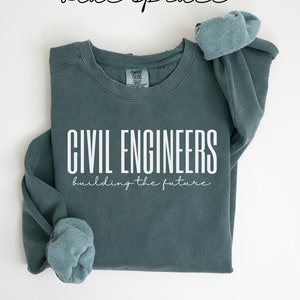May include: A teal blue sweatshirt with the text "CIVIL ENGINEERS building the future" in white.