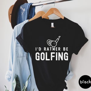 May include: Black t-shirt with a white graphic of a golf club and ball. The text "I'd rather be golfing" is printed in white below the graphic.