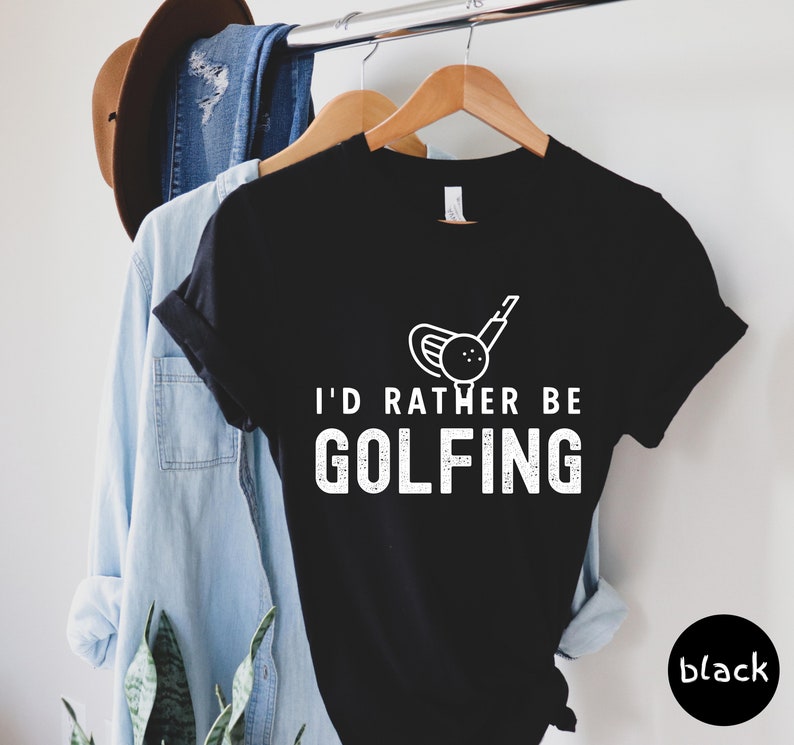 May include: Black t-shirt with a white graphic of a golf club and ball. The text "I'd rather be golfing" is printed in white below the graphic.