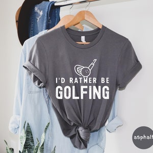 May include: A gray t-shirt with a white graphic of a golf club and ball. The text "I'd rather be golfing" is printed in white below the graphic.
