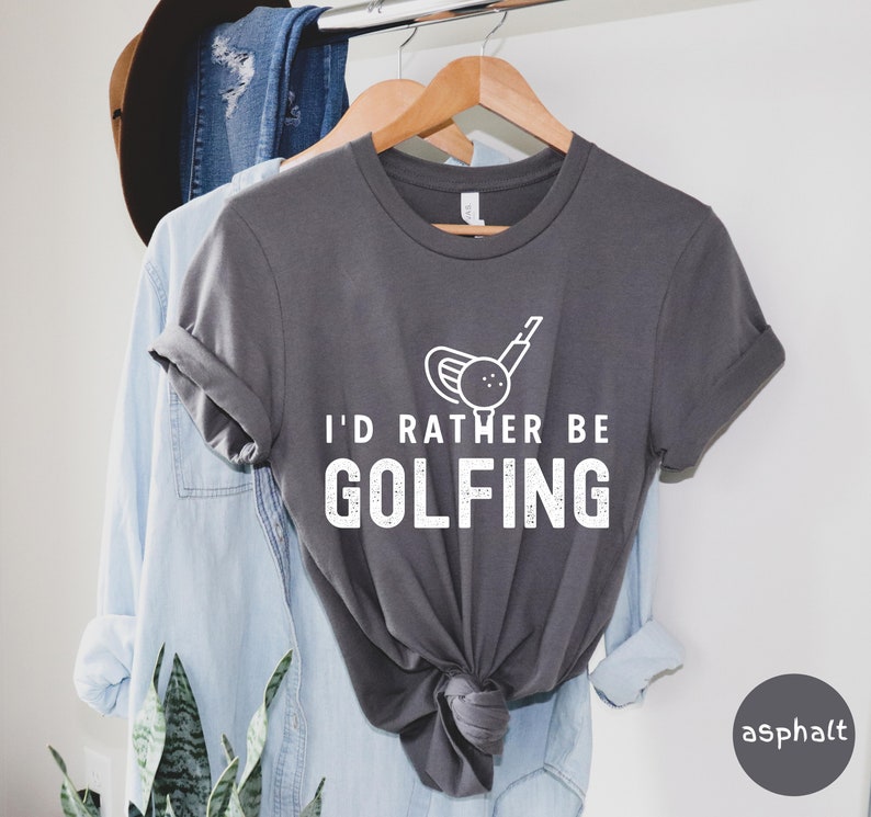 May include: A gray t-shirt with a white graphic of a golf club and ball. The text "I'd rather be golfing" is printed in white below the graphic.