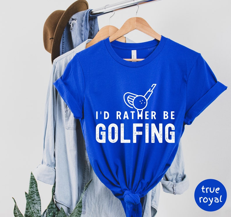 May include: A royal blue t-shirt with white text that reads "I'd rather be golfing" and a white graphic of a golf club and ball.