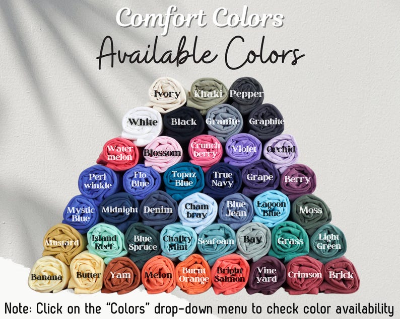 May include: A variety of rolled fabric swatches in different colors, including ivory, khaki, pepper, white, black, granite, graphite, water melon, blossom, crunch berry, violet, orchid, peri winkle, flo blue, topaz blue, true navy, grape, berry, mystic blue, midnight, denim, cham bray, blue jean, lagoon blue, moss, mustard, island reef, blue spruce, chalky mint, seafoam, bay, grass, light green, banana, butter, yam, melon, burnt orange, bright salmon, vine yard, crimson, and brick. The text "Comfort Colors Available Colors" is at the top of the image. The text "Note: Click on the "Colors" drop-down menu to check color availability" is at the bottom of the image.