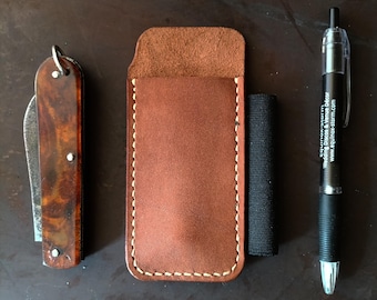 May include: A brown tortoiseshell pocket knife, a tan leather slip case with light-colored stitching, and a black retractable pen with the text "equinox-storm Wedding Discos & Venue Décor www.equinox-storm.com" printed in white on the barrel.