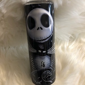 K&ouml;nnte beinhalten: Ein schwarzer und wei&szlig;er Becher mit einem Motiv von Jack Skellington aus Nightmare Before Christmas. Das Motiv zeigt Jacks Gesicht und eine Szene aus dem Film.