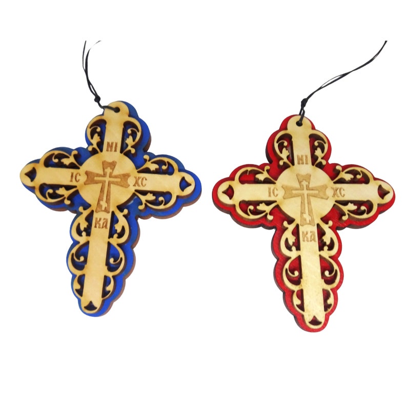 May include: Two wooden crosses with intricate designs. One cross is painted blue and the other is painted red. Both crosses have the words "IC XC NI KA" inscribed on them.