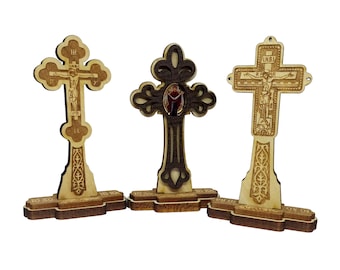 May include: Three wooden crosses with intricate carvings and a religious theme. The crosses are standing on a white background.