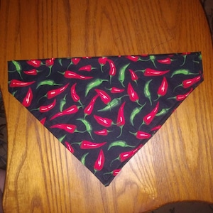 May include: A black bandana with a red and green chilli pepper pattern.