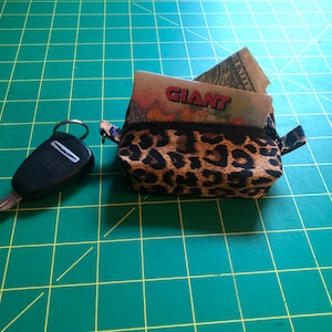 May include: A small leopard print zipped pouch with a key and a folded piece of paper with the word "GIANT" printed on it inside.