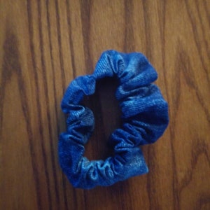 May include: A blue denim scrunchie hair tie.