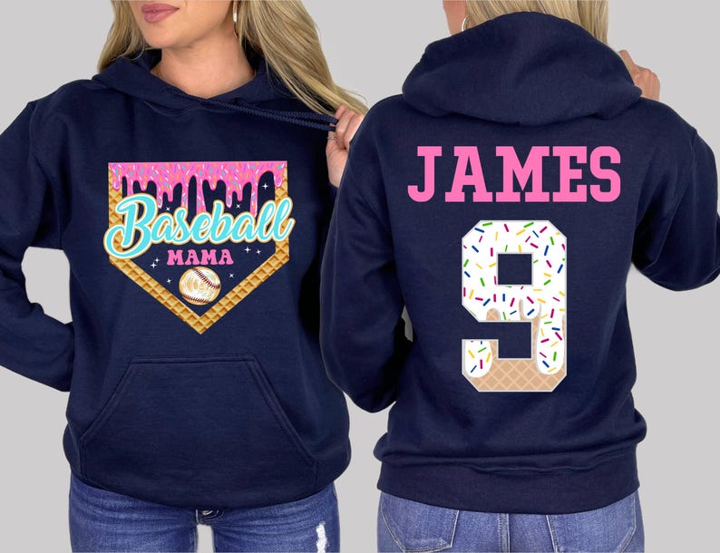 K&ouml;nnte beinhalten: Zwei marineblaue Kapuzenpullover. Ein Pullover hat ein pinkfarbenes und wei&szlig;es Baseball-Motiv mit dem Text "Baseball Mama". Der andere Pullover hat den Text "JAMES" und die Nummer "9" mit einem pinkfarbenen und wei&szlig;en Eiswaffel-Motiv.