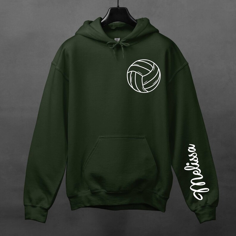 May include: A dark green hooded sweatshirt with a white volleyball graphic on the front and the name "Melissa" printed on the left sleeve.