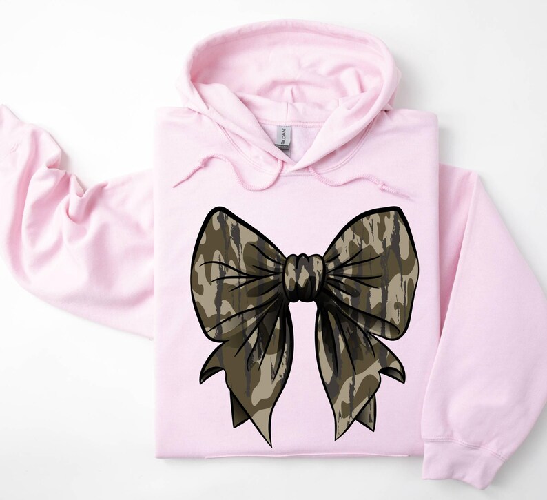 May include: A pink hooded sweatshirt with a large camouflage bow on the front.