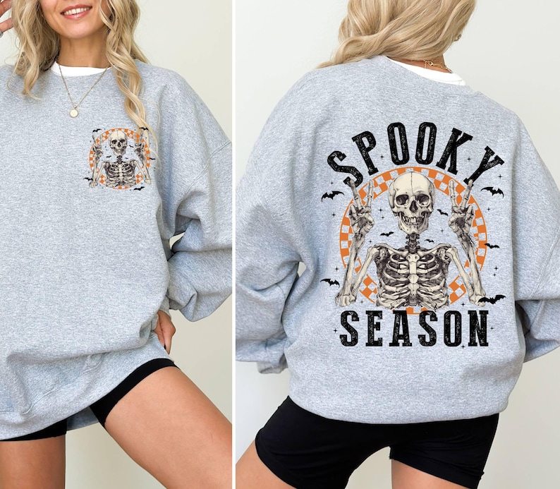 Puede incluir: Sudadera gris con un gr&aacute;fico de esqueleto y el texto "Spooky Season".