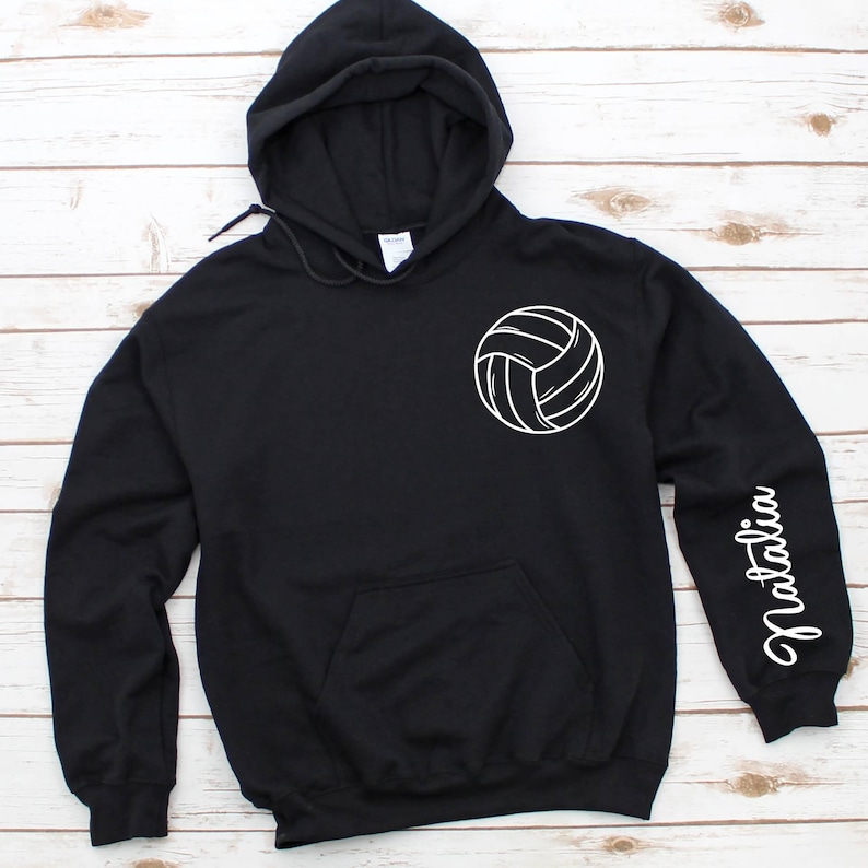 May include: Black hooded sweatshirt with a white volleyball graphic on the front and the name "Natalia" on the sleeve.
