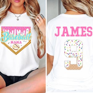 May include: White t-shirt with a pink and white baseball graphic that says "Baseball Mama" and a white t-shirt with the name "JAMES" and the number "9" with sprinkles on it.