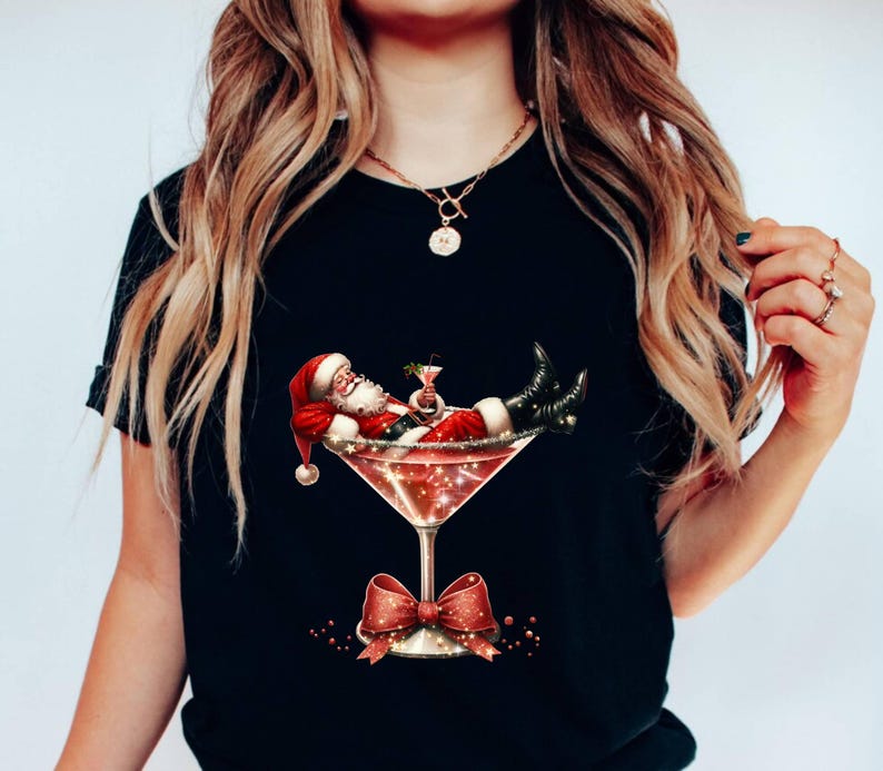May include: A black t-shirt with a graphic of Santa Claus relaxing in a martini glass. The glass is filled with a red liquid and has a red bow on the stem.
