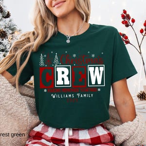 May include: A forest green Christmas Crew t-shirt with red and white text. The text includes "Christmas Crew", "Making Memories Together", "Williams Family", and the year 2023. The shirt has a crew neck and short sleeves.