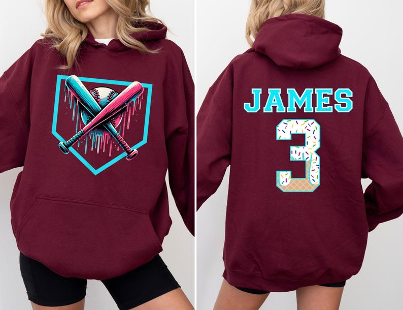 May include: Burgundy hoodie with a baseball-themed graphic on the front, featuring crossed bats and a baseball within a home plate outline. The back displays the name "JAMES" and the number "3" with a dessert-themed design.